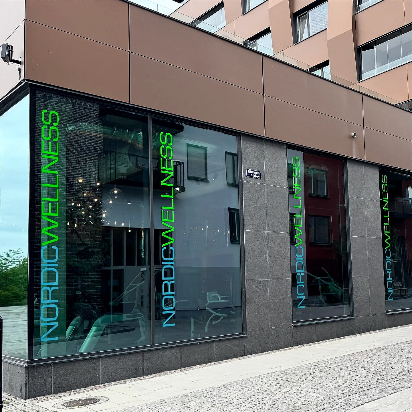 Nordic Wellness vertical coloured window branding on a building