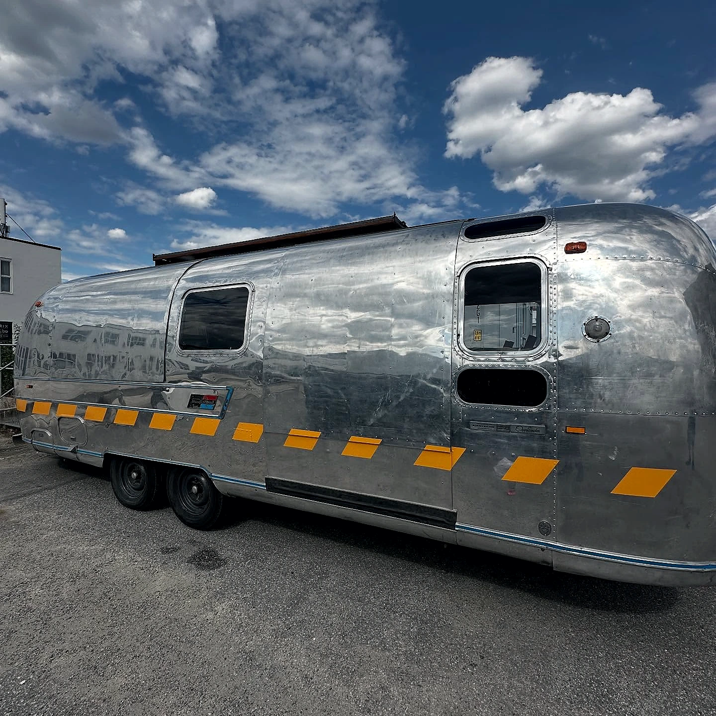 Polished silver trailer with bold yellow branding graphics